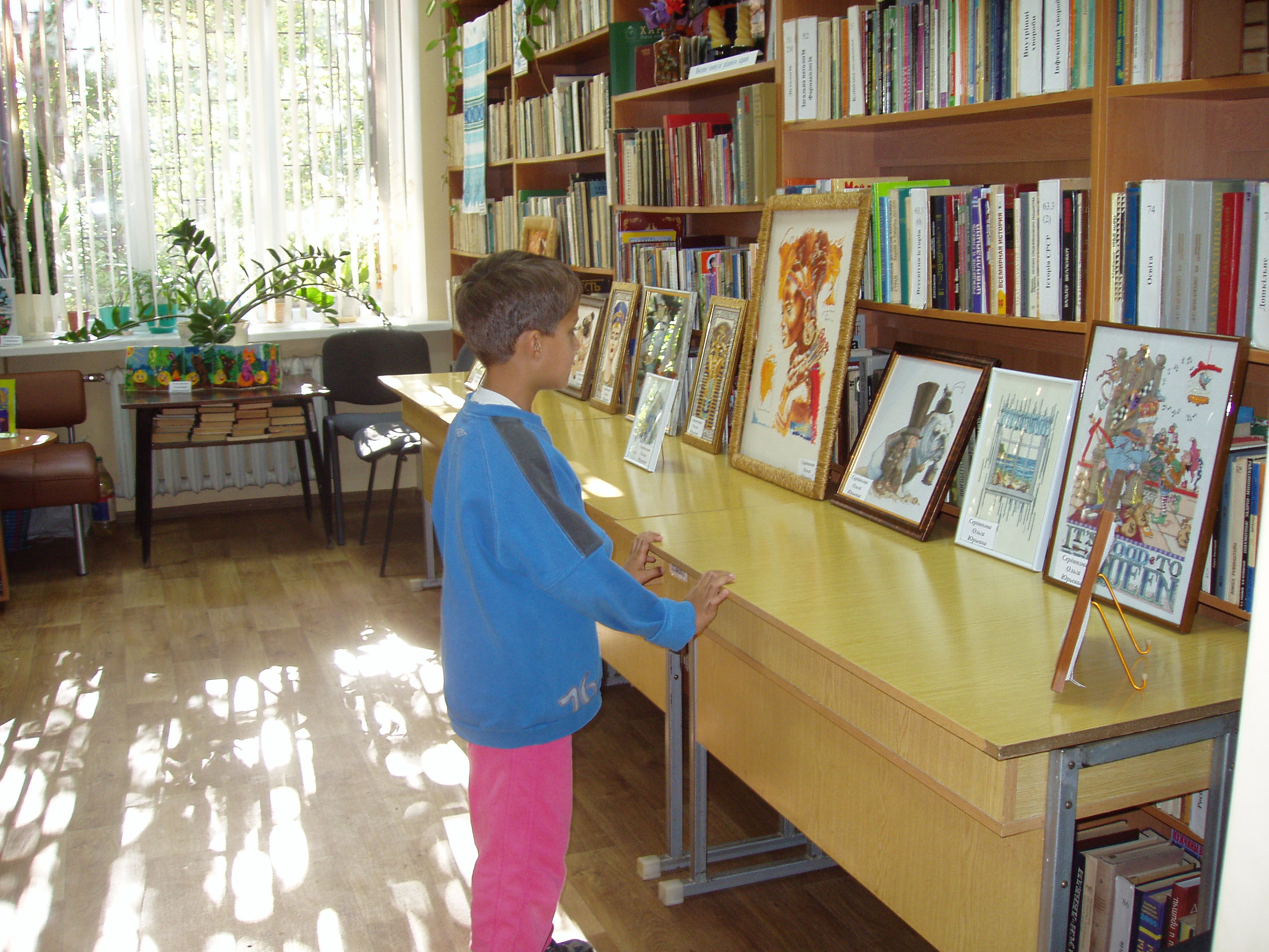 Самий юний читач бібліотеки - філії № 22 милується роботами майстрів вишивки